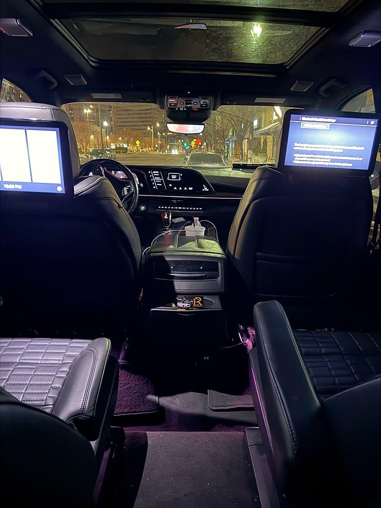 Cadillac Escalade ESV rear cabin with dual entertainment screens, quilted leather and ambient lighting