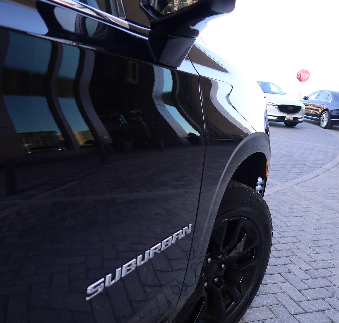 Rear-quarter detail of a black Chevrolet Suburban with the chrome Suburban badge
