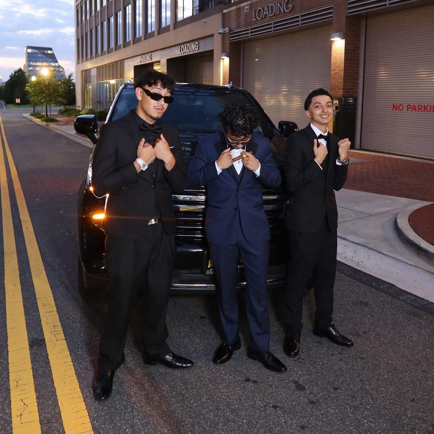 A group beside a black SUV at dusk